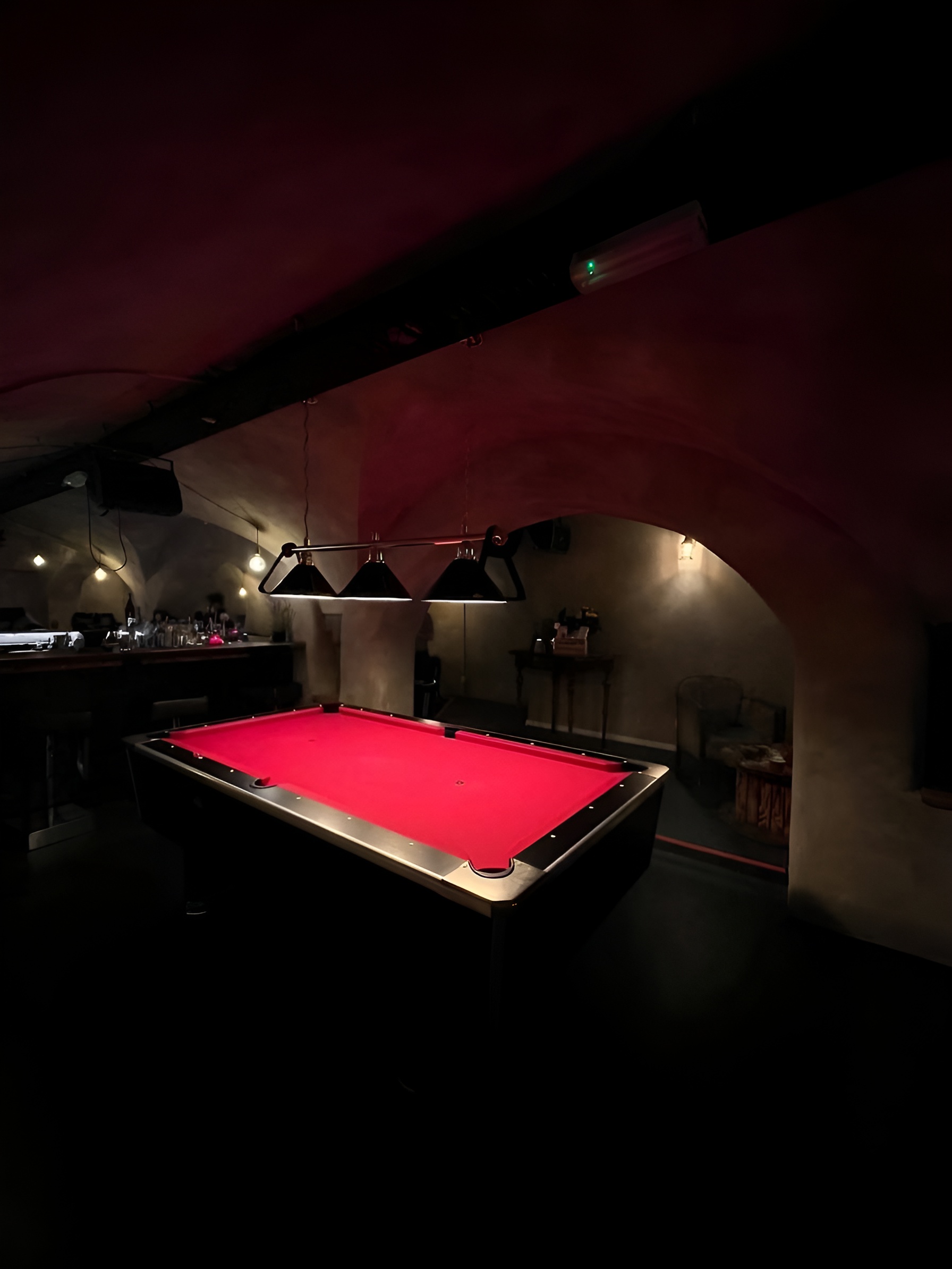 Blick in das Gewölbe mit rotem Billardtisch und Bar